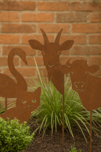 Rustic metal garden sculptures displayed on grass including cat, swan, goat, and cow designs